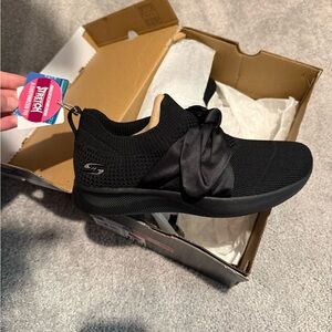 Skechers Women’s Black Slip-On Knit Sneaker with Satin Bow Accent